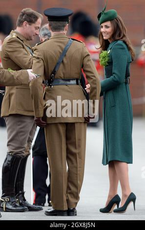 Catherine, Herzogin von Cambridge, trägt einen Kleeblatt, während sie mit Soldaten während der St. Patrick's Day Parade in Mons Barracks in Aldershot am 17. März 2014 plaudert. Stockfoto