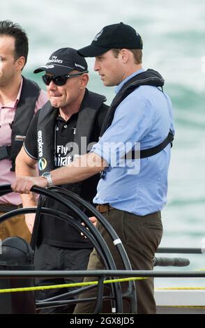 Prinz William, Herzog von Cambridge, übernimmt das Ruder einer America's Cup Yacht, als er am 11. April 2014 in Aukland Harbour, Neuseeland, die Herzogin von Cambridge, in Rennen fährt. Die Herzogin hat gewonnen. Stockfoto