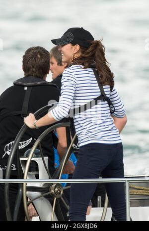 Catherine, Herzogin von Cambridge, übernimmt das Ruder einer America's Cup-Yacht, als sie am 11. April 2014 im neuseeländischen Aukland Harbour mit Prinz William fährt. Die Herzogin hat gewonnen. Stockfoto