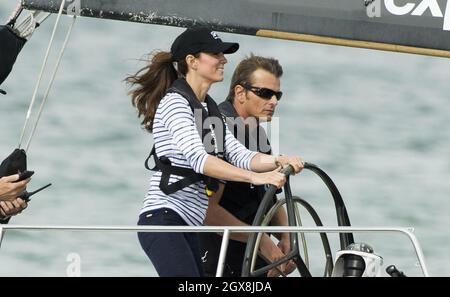 Catherine, Herzogin von Cambridge, übernimmt das Ruder einer America's Cup-Yacht, als sie am 11. April 2014 im neuseeländischen Aukland Harbour mit Prinz William fährt. Die Herzogin hat gewonnen. Stockfoto