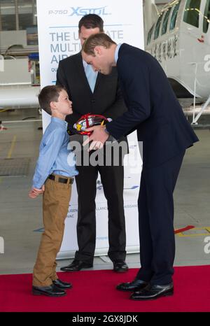 Prinz William, Herzog von Cambridge, erhält ein Geschenk von einem Jungen während eines Besuchs bei Pacific Aerospace in Hamilton, Neuseeland Stockfoto