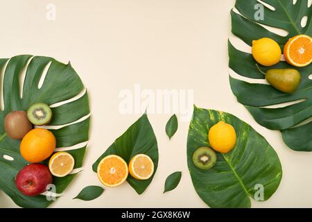 Direkt über Ansicht von frischen reifen Früchten auf tropischen Blättern auf isoliertem Hintergrund Stockfoto