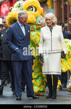 Prinz Charles, Prinz von Wales und Camilla, Herzogin von Cornwall posieren mit einem tanzenden Drachen während eines Besuchs in Chinatown in London zum chinesischen Neujahr am 19. Februar 2015. Stockfoto