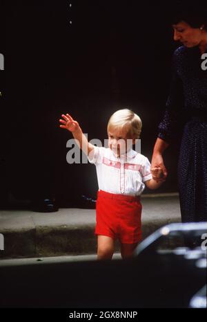 Ein junger Prinz William, begleitet von dem Kindermädchen Barbara Barnes, verlässt am 16. September 1984 das St. Mary's Hospital in London, nachdem er seinen neugeborenen Bruder Prinz Harry gesehen hat. Prinz George wird in derselben Kleidung gesehen, wie er am 5. Juli 2015 an der Taufe seiner kleinen Schwester Prinzessin Charlotte teilnimmt Stockfoto