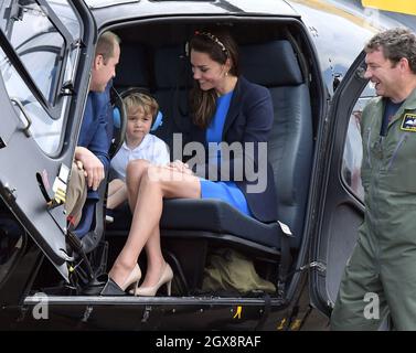 Catherine, Herzogin von Cambridge, Prinz William, Herzog von Cambridge und Prinz George, tragen Banz-Ohrverteidiger, um ihn vor dem Lärm zu schützen, sitzen in einem Eichhörnchen-Hubschrauber während eines Besuchs des Royal International Air Tattoo bei RAF Fairford am 8. Juli 2016. Stockfoto