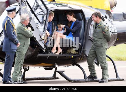 Catherine, Herzogin von Cambridge, Prinz William, Herzog von Cambridge und Prinz George, tragen Banz-Ohrverteidiger, um ihn vor dem Lärm zu schützen, sitzen in einem Eichhörnchen-Hubschrauber während eines Besuchs des Royal International Air Tattoo bei RAF Fairford am 8. Juli 2016. Stockfoto