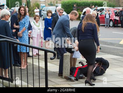 Prinz William, Herzog von Cambridge, beobachtet von Catherine, Herzogin von Cambridge, eilt Jonathan Douglas-Hughes, dem Vizeleiterleutnant von Essex, zu Hilfe, der fiel, als das königliche Paar am 16. September 2016 in der Stewards Academy in Harlow in Essex eintrifft. Stockfoto