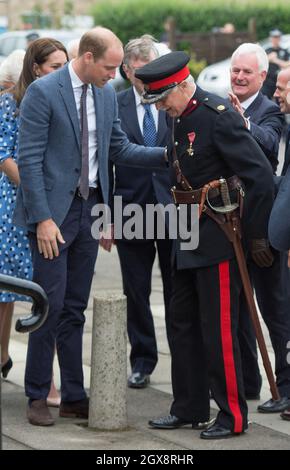 Prinz William, Herzog von Cambridge, beobachtet von Catherine, Herzogin von Cambridge, eilt Jonathan Douglas-Hughes, dem Vizeleiterleutnant von Essex, zu Hilfe, der fiel, als das königliche Paar am 16. September 2016 in der Stewards Academy in Harlow in Essex eintrifft. Stockfoto