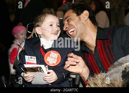 Der vierjährige Matthew Johnson chattet mit dem X-Factor-Kandidaten Chico während der Verleihung der Women's Own Children Courage Awards in Westminster Abbey, London. Matthew ist allergisch auf nahezu jede Lebensmittelart und muss ständig mit spezieller Milch in den Röhrchen gefüttert werden. Anwar Hussein/allactiondigital.com Stockfoto