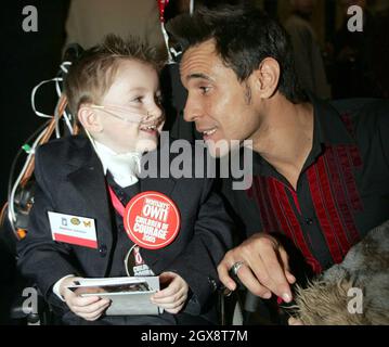 Der vierjährige Matthew Johnson chattet mit dem X-Factor-Kandidaten Chico während der Verleihung der Women's Own Children Courage Awards in Westminster Abbey im Zentrum von London. Matthew ist allergisch auf nahezu jede Lebensmittelart und muss ständig mit spezieller Milch in den Röhrchen gefüttert werden. Anwar Hussein/allactiondigital.com Stockfoto