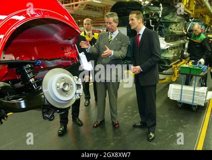 Der Prinz von Wales betrachtet einen Mini im Cowley-Werk von BMW in Oxfordshire während einer Tour durch die Produktionslinie. Der Prinz traf einige der 4,500 Mitarbeiter, die bei der Produktion des neuen Mini mithelfen, der im Juli 2001 eingeführt wurde. â©Anwar/allaction.co.uk Stockfoto