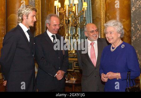 Die Königin trifft Sven Goran Eriksson, David Beckham und das englische Fußballteam während eines Empfangs für den Fußballverband, der einen Buckingham-Palast abgehalten hat. Die 75 starke England-Party, einschließlich Hinterzimmer-Personal sowie hochkarätige Spieler und Management, kam im Palast in drei Trainern. Der Empfang mit Getränken und Häppchen fand im Blue Drawing Room des Palastes statt, wo der Vorsitzende des Verbands, Geoffrey Thompson, zusammen mit dem englischen Trainer und Kapitän die erste Begegnung mit der Königin aufführte. Halbe Länge. Stockfoto