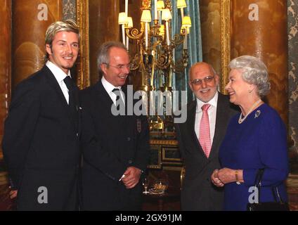 Die Königin trifft Sven Goran Eriksson, David Beckham und das englische Fußballteam während eines Empfangs für den Fußballverband, der einen Buckingham-Palast abgehalten hat. Die 75 starke England-Party, einschließlich Hinterzimmer-Personal sowie hochkarätige Spieler und Management, kam im Palast in drei Trainern. Der Empfang mit Getränken und Häppchen fand im Blue Drawing Room des Palastes statt, wo der Vorsitzende des Verbands, Geoffrey Thompson, zusammen mit dem englischen Trainer und Kapitän die erste Begegnung mit der Königin aufführte. Halbe Länge. Stockfoto