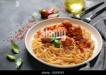 Pasta Spaghetti mit Fleischbällchen und Tomatensauce auf einem weißen Platte auf dunklem Hintergrund Stockfoto