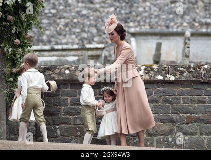 Catherine, Herzogin von Cambridge, chattet nach der Hochzeit von Pippa Middleton und James Matthews in der St. Mark's Church, Englefield Green, den Jungen Prinz George und das Blumenmädchen Prinzessin Charlotte Stockfoto