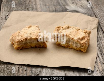 Quadratische gebackene Plätzchen liegen auf einem Stück Papier, grauer Holztisch, polnische Plätzchen, Draufsicht Stockfoto