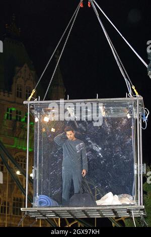 David Blaine tritt an der Tower Bridge in eine Glasbox ein und wird 40ft über der Themse aufgehängt, wo er hofft, 44 Tage ohne Nahrung zu überleben. Stockfoto