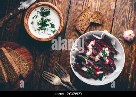 Gebackene Zuckerrüben Pommes mit griechischem Joghurt und Dill Dressing Stockfoto
