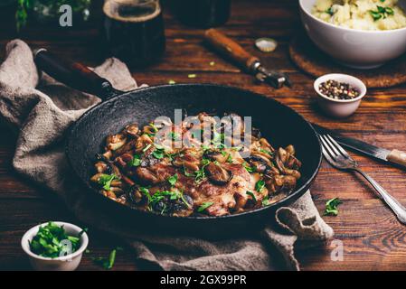 Gebratenes Schweinehals Steak mit verschiedenen Pilzen Gusseisen Pfanne Stockfoto