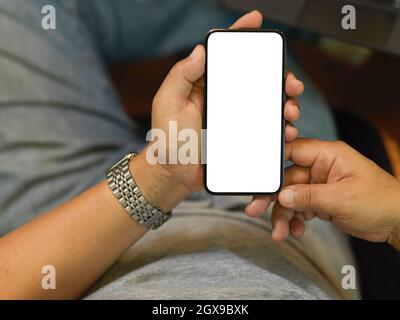 Ausgeschnittene Aufnahme eines gealterten Geschäftsmanns mit Smartphone, um mit seinem Geschäftskunden in Kontakt zu treten. Mit Mobiltelefon, leerer Bildschirm-Mockup Stockfoto