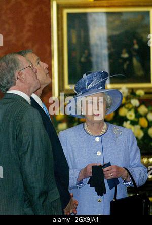 US-Präsident George W.Bush (C) blickt mit US-Botschafter William Farish (L) auf die Kunst an den Wänden der Queen's Gallery im Buckingham Palace, während die britische Königin Elizabeth II. (R) während seines Staatsbesuchs schaut. â©Anwar Hussein/allactiondigital.com Stockfoto