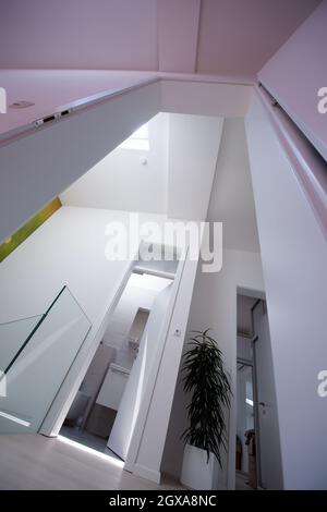 Blick auf die Decke mit Halogenstrahlern und Dachfenstern in Wohnung oder Haus. Stretchdecke weiß und komplex Stockfoto