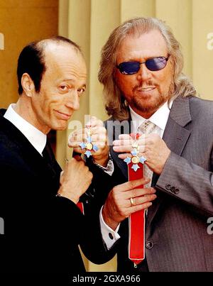 Die beiden überlebenden Mitglieder der Bee Gees, Robin (links) und Barry Gibb, halten ihre CBE, nachdem sie vom Prince of Wales am Donnerstag, 27. Mai 2004, im Buckingham Palace, London, empfangen wurden. Der dritte Bruder, Maurice Gibb, starb letztes Jahr, bevor er die Ehre erhalten konnte, und so sammelte sein Sohn Adam sie für ihn ein. Stockfoto