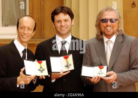 Die beiden überlebenden Mitglieder der Bee Gees, Robin Gibb (links) und Barry Gibb (rechts) halten ihre CBE zusammen mit Adam Gibb, der die Ehre im Namen seines Vaters, des verstorbenen Maurice Gibb, am Donnerstag, dem 27. Mai 2004, im Buckingham Palace, London, erhielt. Alle drei Brüder wurden mit CBE ausgezeichnet, obwohl Maurice Gibb letztes Jahr starb, bevor er die Ehre erhalten konnte Stockfoto