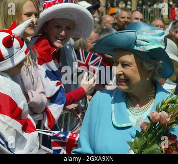 Die britische Königin Elizabeth II. Trifft sich in der Piece Hall in Halifax, Yorkshire, einem ehemaligen Marktplatz für lokale Weber, der heute ein blühendes Geschäftszentrum für kleine Händler ist, die sich auf kreative Kunst spezialisiert haben, am Donnerstag, den 27. Mai 2004. Sie und der Herzog von Edinburgh sahen sich eine Aufführung einer lokalen Theatergruppe an, die sich auf den Einsatz von Drama spezialisiert hat, um das Vertrauen junger Menschen zu stärken, Und vor der Königin besuchte er die Halifax High School, wo ein 11-jähriger Schüler ihr einen schicken gab - nachdem er sich eine Münze angeschaut hatte, um zu sehen, wer sie war. Stockfoto