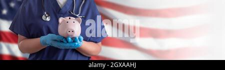 Arzt oder Krankenschwester tragen OP-Handschuhe halten Piggy Bank über amerikanischen Flagge Banner. Stockfoto