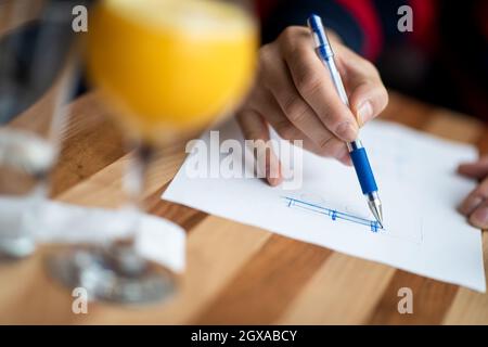 Die Hand des Designers mit einem Stift, der seine Idee für ein Möbelprodukt entworfen und skizziert Stockfoto