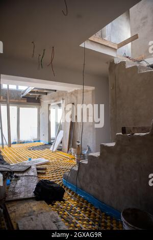 Gelbe Fußbodenheizung mit weißen Polyethylenrohren auf der Baustelle der neuen zweistöckigen Wohnung Stockfoto