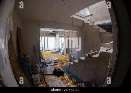 Gelbe Fußbodenheizung mit weißen Polyethylenrohren auf der Baustelle der neuen zweistöckigen Wohnung Stockfoto