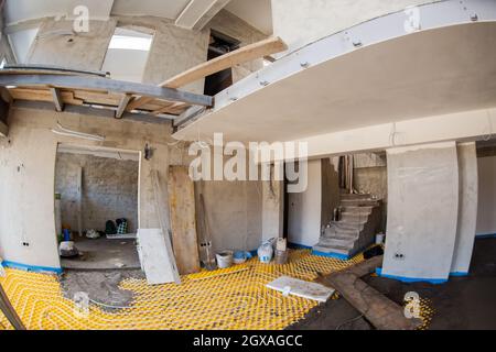 Gelbe Fußbodenheizung mit weißen Polyethylenrohren auf der Baustelle der neuen zweistöckigen Wohnung Stockfoto