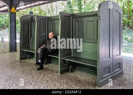 Der S-Bahnhof Frohnau bedient die S1-Bahnlinie des Berlin-Brandenburg-Nahverkehrsnetzes.Ältere Männer sitzen auf einer hölzernen bech-Plattform Stockfoto