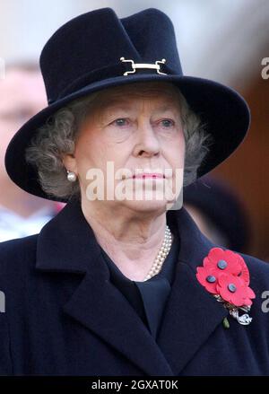 Die britische Königin Elizabeth II. Steht am Donnerstag, den 11. November 2004, während eines Dienstes zum Waffenstillstandstag auf dem Gelände der Londoner Westminster Abbey. Hunderte von kleinen Holzkreuzen, die auf dem Gelände der Abtei gepflanzt und mit einem blutroten Mohnblumen geschmückt sind, tragen den Namen eines gefallenen Angehörigen und die Botschaft des Gedenkens. Anwar Hussein/allactiondigital.com Stockfoto