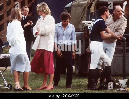 Diana, die Prinzessin von Wales, schwanger mit Prinz Harry, chattet während eines Poloevents mit Prinz Charles, während der Bodyguard Barry Mannakee (zweiter von links) auf diesem Juni1984-Foto in Windsor, England, schaut. Ein in den USA veröffentlichtes Videoband von Diana Speaking im Jahr 1992 zeigt ihr, dass sie vor Prinz Charles fliehen und mit Mannakee leben wollte. Diana äußert auch Befürchtungen, dass Mannakee ermordet wurde, als er 1987 bei einem Motorradunfall ums Leben kam. Stockfoto