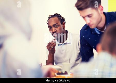 African American man Iftar gemeinsam das Abendessen genießen mit modernen multiethnischen muslimische Familie während des Ramadan Fest zu Hause Stockfoto