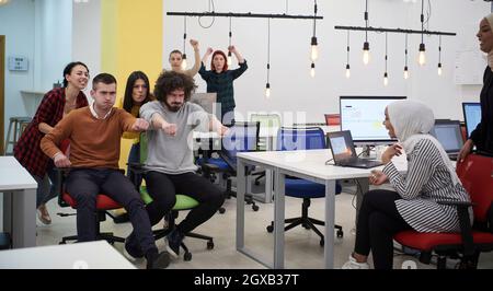 Geschäftsleute, die Spaß haben, während sie auf Bürostühlen Rennen Stockfoto