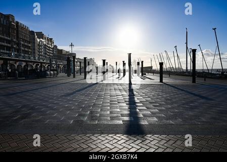 Brighton UK 2. Oktober 2021 - Spaziergänger an der Küste von Brighton an der Golden Spiral, wenn die Sonne nach einer Nacht mit heftigem Regen und starken Winden im Südosten Großbritanniens aufgeht : Credit Simon Dack / Alamy Live News Stockfoto