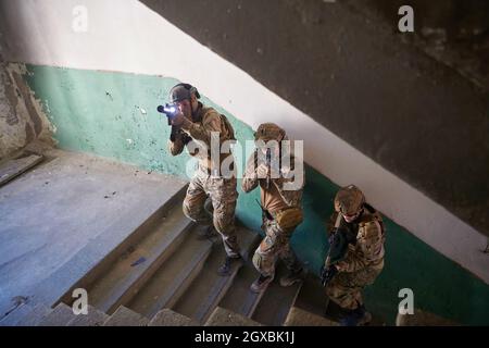 Special Forces Trupp Team von uns Marines Soldaten besteigen Treppen in taktischer Formation Stockfoto