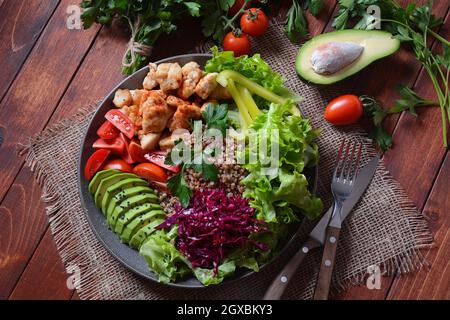 Buddha Schüssel oder Salat mit Rotkohl, Kirschtomaten, gegrilltem Huhn, Avocado, Salat, grünem Pfeffer, Petersilie und Buchweizen. Gesunde Ernährung Konzept Stockfoto