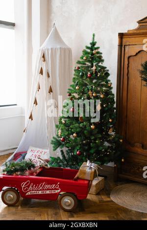 Weihnachtsbaum, Holzschrank aus Vintage-Holz, Spielzeugauto für Kinder, Tipi oder Zelt Stockfoto