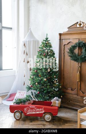 Weihnachtsbaum, Holzschrank aus Vintage-Holz, Spielzeugauto für Kinder, Tipi oder Zelt Stockfoto