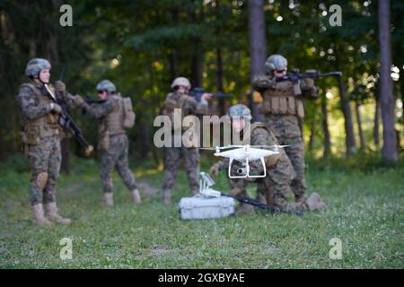 Modern Warfare Soldiers Squad verwenden Drohne für Scouting und Überwachung während der militärischen Operation im Wald. Stockfoto