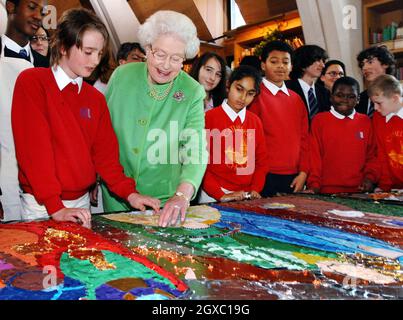 Königin Elizabeth II. Legt kleine Spiegelfliesen um den Kopf des Jesuskindes auf eine Krippencollage, die von Schulkindern in der Southwark Cathedral am 7. Dezember 2006 in London, England, angefertigt wurde. Die Kinder und ihre Kunstwerke sind in der diesjährigen Weihnachtssendung von her Majestät zu sehen. Die Weihnachtsrede der Königin in diesem Jahr zeigt, wie alle Religionen die Notwendigkeit betonen, die Jungen zu ernähren und zu führen. In ihrer Botschaft vom 25. Dezember wird die Monarch über die Bedeutung der Beziehung zwischen den Generationen sprechen. Sie wird sagen: 'Die Weisheit und Erfahrung der großen Religionen deuten auf die Notwendigkeit hin, ein zu nähren Stockfoto