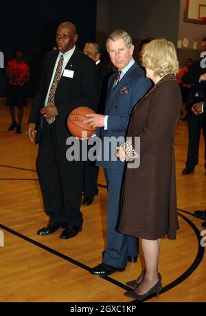 Prinz Charles, Prinz von Wales, bereitet sich auf den Schuss vor, während Camilla, Herzogin von Cornwall, bei Basketballübungen in der Harlem Children's Zone, einem Projekt, das benachteiligten Kindern helfen soll, ihr volles Potenzial auszuschöpfen, am 28. Januar 2007 in New York amüsiert wirkt. Anwar Hussein/EMPICS Entertainment Stockfoto