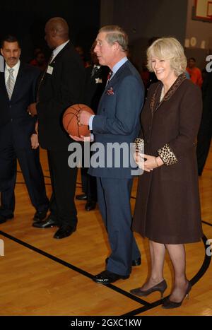 Prinz Charles, Prinz von Wales, bereitet sich auf den Schuss vor, während Camilla, Herzogin von Cornwall, bei Basketballübungen in der Harlem Children's Zone, einem Projekt, das benachteiligten Kindern helfen soll, ihr volles Potenzial auszuschöpfen, am 28. Januar 2007 in New York amüsiert wirkt. Anwar Hussein/EMPICS Entertainment Stockfoto