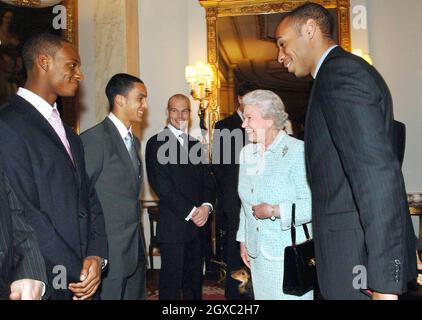 Königin Elizabeth II trifft am 15. Februar 2007 im Buckingham Palace in London die Fußballnationalmannschaft von Arsenal (von links nach rechts), Justin Hoyte, Theo Walcott, Freddie Ljungberg und Kapitän Thierry Henry (rechts). Stockfoto