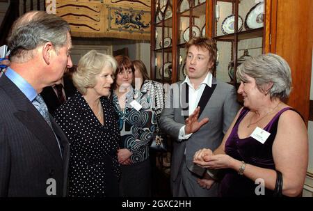 Prinz Charles, Prinz von Wales und Camilla, Herzogin von Cornwall, unterhalten sich mit Fernsehkoch Jamie Oliver und Norah Sands (R) während eines Empfangs für Schulköche im Clarence House in London am 15. Februar 2007. Stockfoto